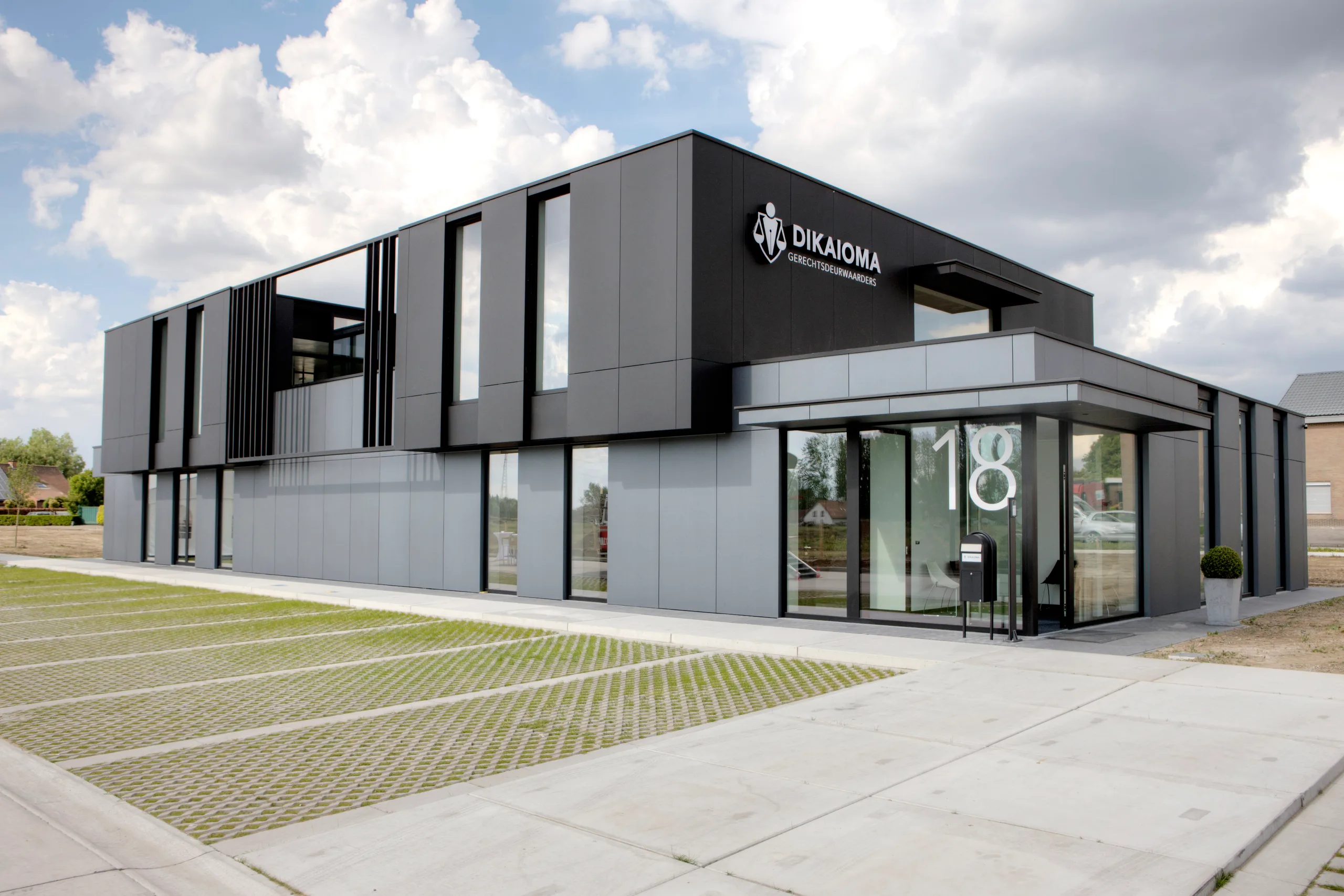Moderne woning met zwarte en witte gevelbekleding en grote raampartijen aan de voorkant