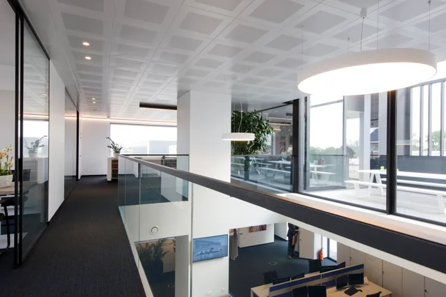 Moderne kantoorruimte met glazen balustrade, hoogwaardige verlichting en grote raampartijen met uitzicht