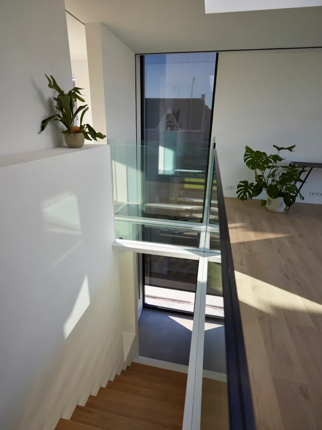 Trap met glazen wand en groot raam dat veel licht binnengeeft