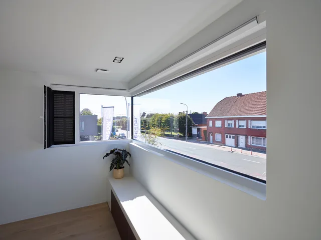 Ruime vensterbank met groot raam dat uitkijkt over straat en dorpsgezicht