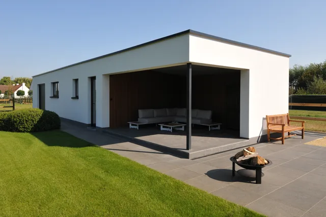 Moderne woning met witte gevel en grote terrasoverkapping aan tuinzijde
