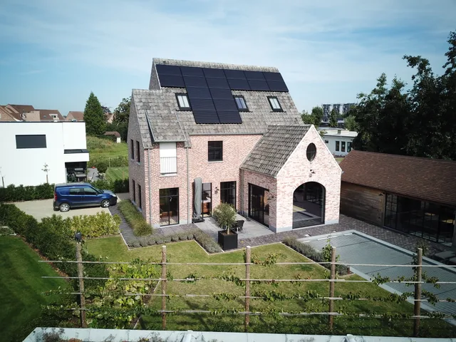 Moderne woning met bakstenen gevel, schuine dakpartij met zonnepanelen en ingebouwde garage