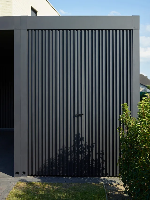 Grijze garagedeur met verticale lamellen en modern design