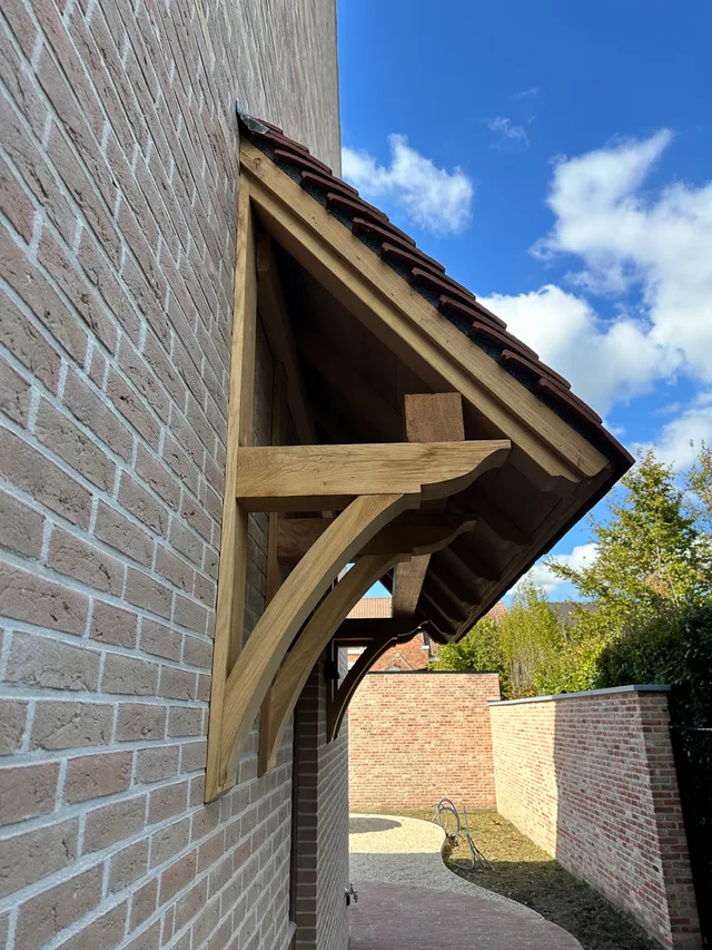 Detail van houten luifel aan bakstenen voorgevel