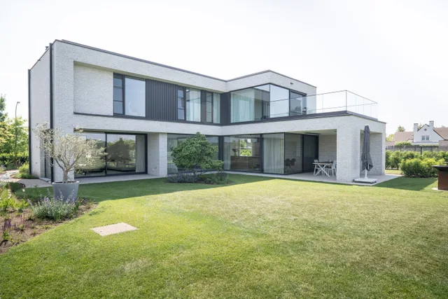 Modern woonhuis met vlakke daken, grote raampartijen en aangrenzend gazon