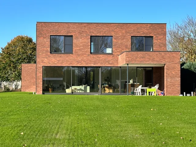 Moderne bakstenen woning met uitsluitend grote glaspartijen op de tuinzijde