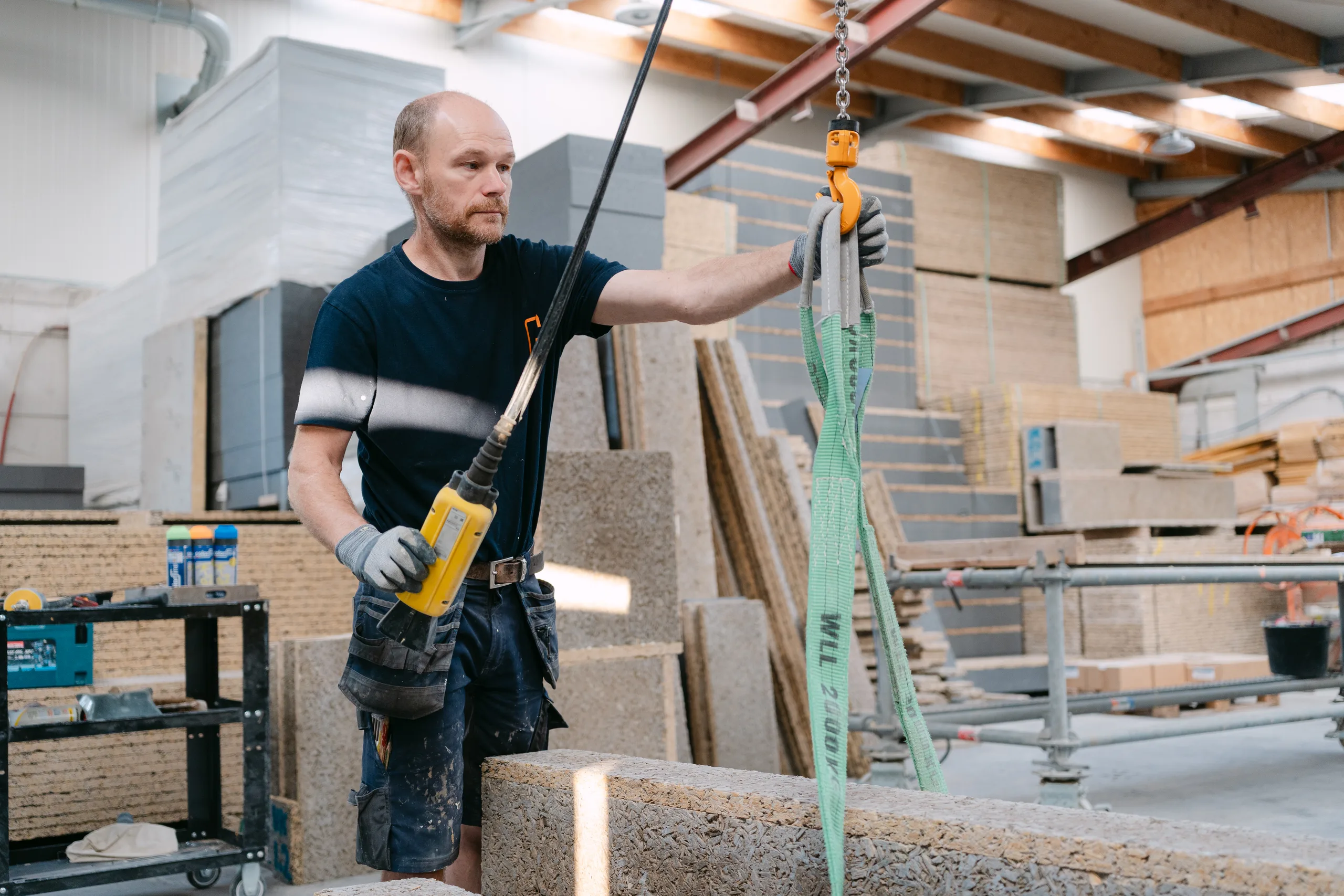 Werker hijst betonnen blokken op een bouwwerf in aanbouw