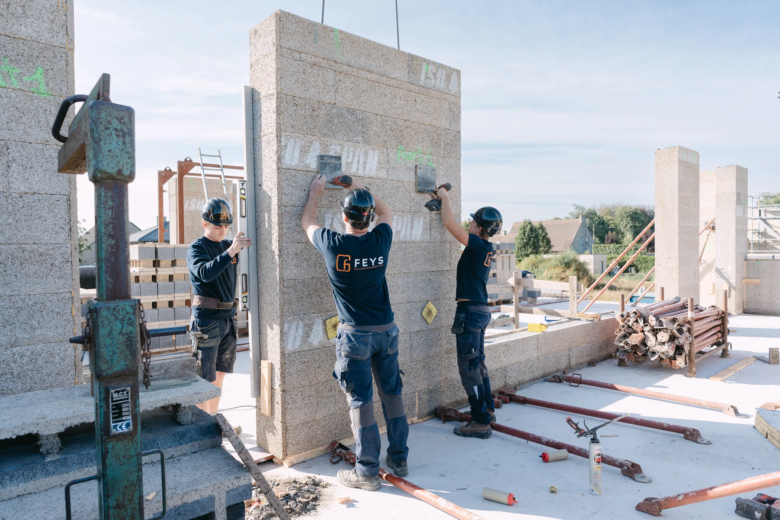 Bouwvakkers plaatsen betonnen wanden op een actieve werf