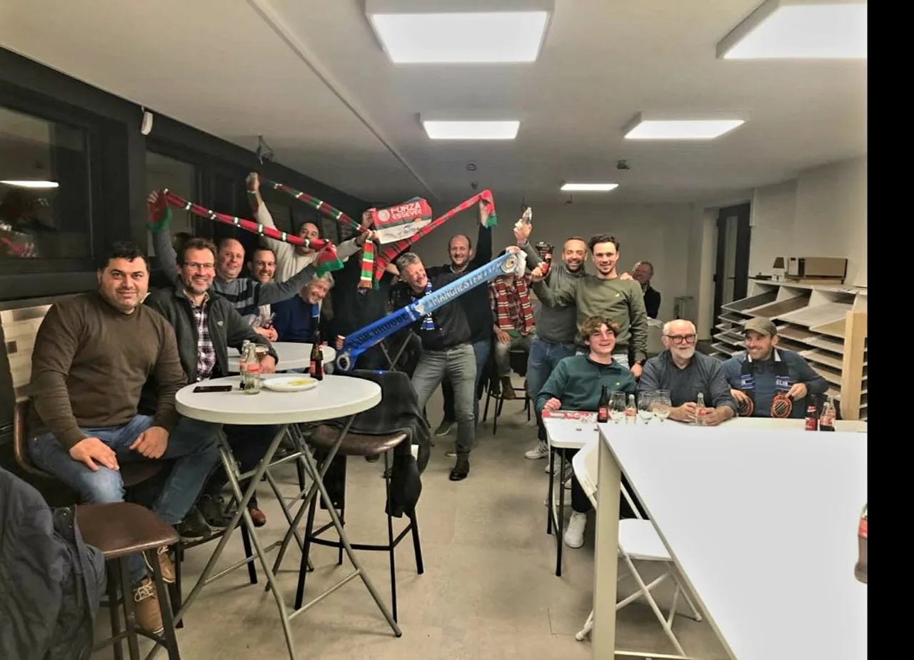 Groep mensen viert samen in een kantoorruimte met voetbalsjaal en enthousiasme