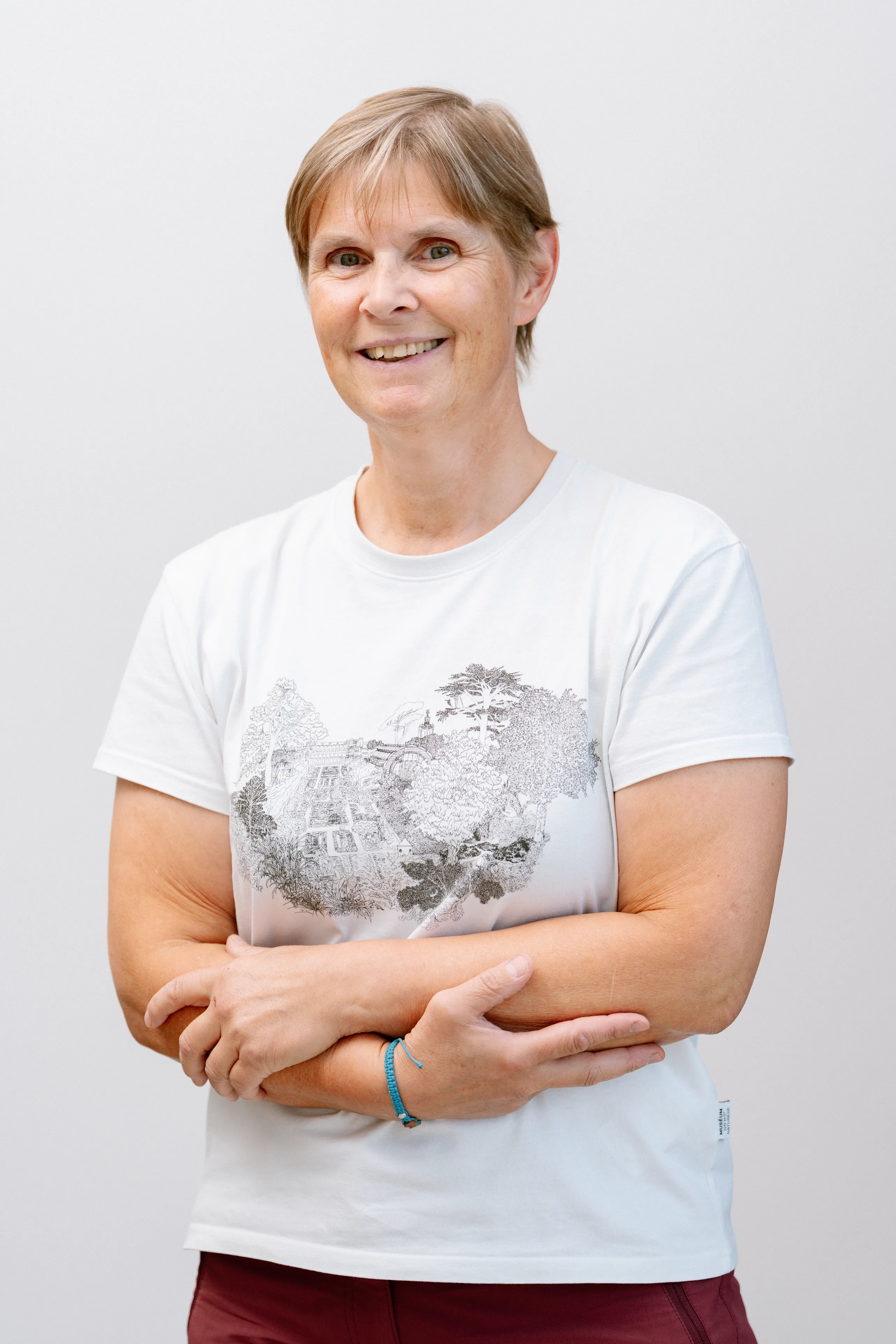 Portret van een vrouw die lacht naar de camera met gevouwen armen