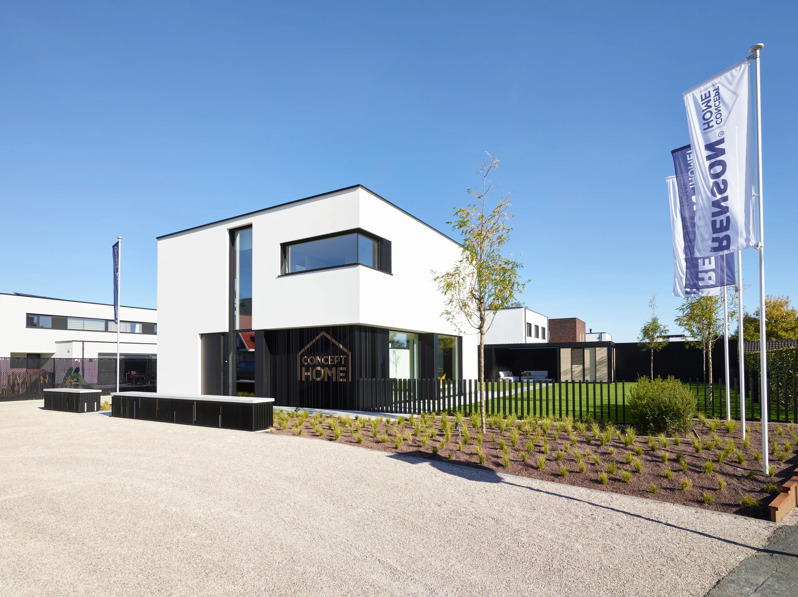 Moderne woning met witte gevels, grote raampartijen en zwarte accenten rond de ingang